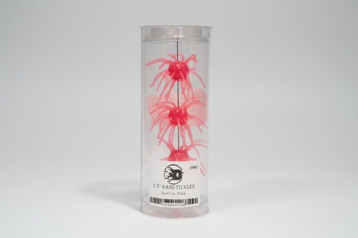 Pink fishing lure in a clear container with a label.