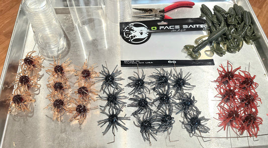 Assorted fishing lures on a tray with a O face brand label in the background.