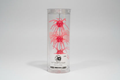 Pink fishing lure in a clear container with a label.